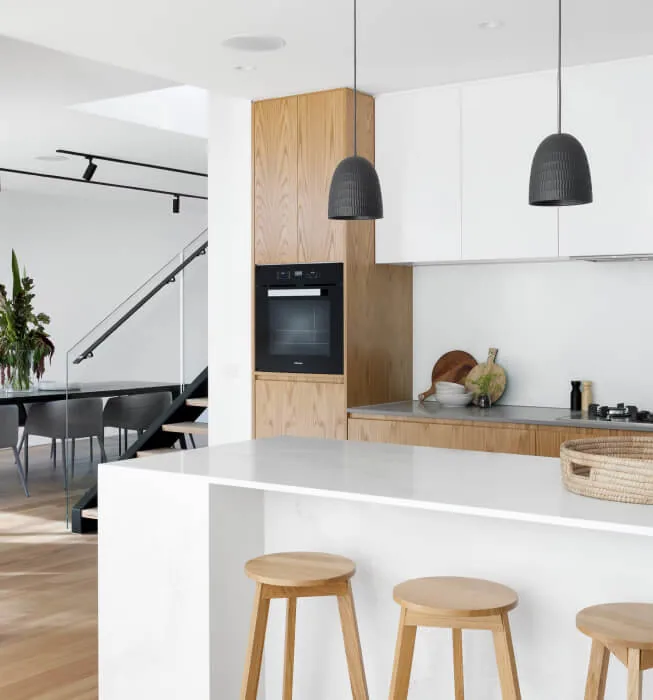 Modern kitchen with a marble island, pendant lights and pale timber cabinetry